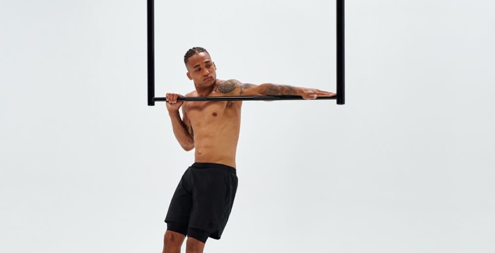 Athlete performing typewriter pull-ups to build bodyweight strength using the greasing the groove method.