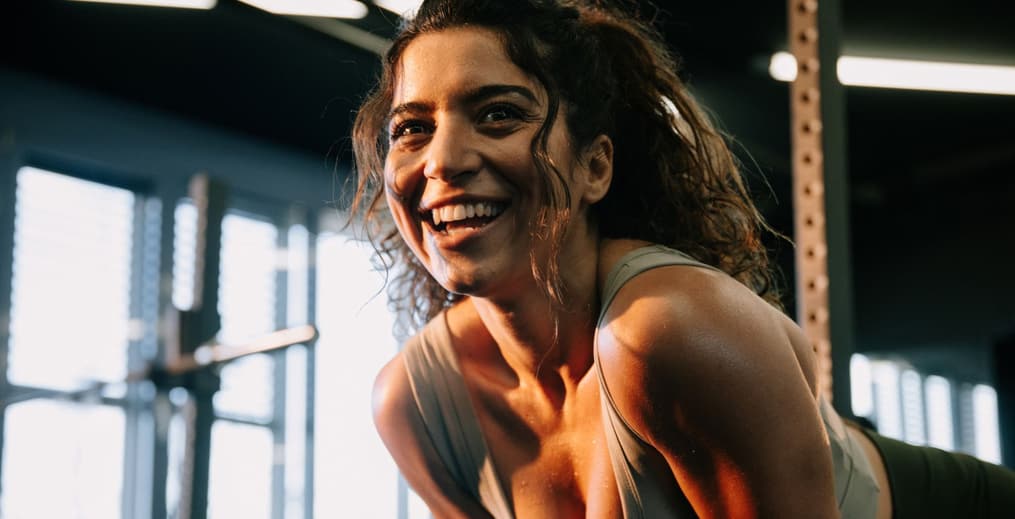 Woman smiling after a workout, showing the mood boost from exercise and happy hormones.