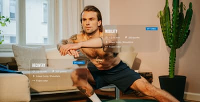 Man stretching in his apartment using the Freeletics Mobility Days to maintain muscle and joint health.