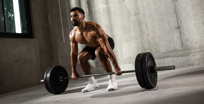 Hybrid athlete preparing for a barbell deadlift during strength training