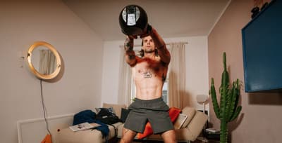 Athlete performing kettlebell swings at home to build strength and endurance.
