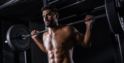 Athlete preparing for a heavy back squat to illustrate the difference between performance training and aesthetic goals.