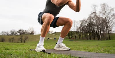 Athlete’s lower legs in motion, showing strong foot and ankle muscles during a squat.