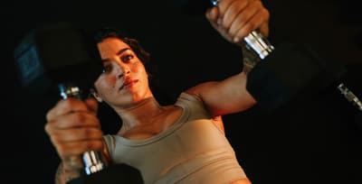 Athlete performing dumbbell bench presses in a gym, showcasing upper body strength and stability.