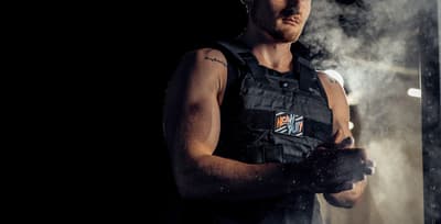 Athlete wearing a weighted vest during a workout, demonstrating the benefits of added resistance for strength and endurance training.