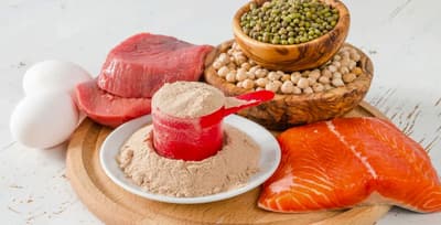 A variety of high-quality protein sources like chicken, eggs, and beans on a cutting board.