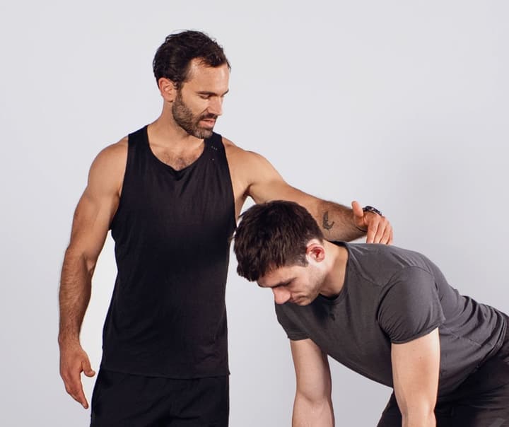 Zertifizierter Personal Trainer korrigiert die Technik bei einer Kraftübung