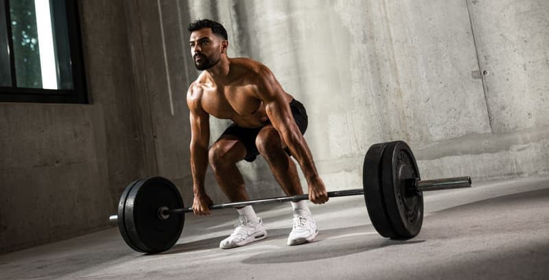 Hybrid athlete preparing for a barbell deadlift during strength training