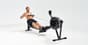 A fitness athlete demonstrating the finish phase of a rowing stroke on an indoor ergometer to highlight the health benefits of rowing.