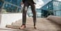 Man in a business suit taking the stairs instead of the elevator as a movement snack to improve fitness.