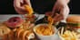 A table filled with various types of junk food, including chips, burgers, and sugary drinks.